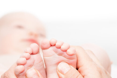 Little baby receiving chiropractic or osteopathic foot massage